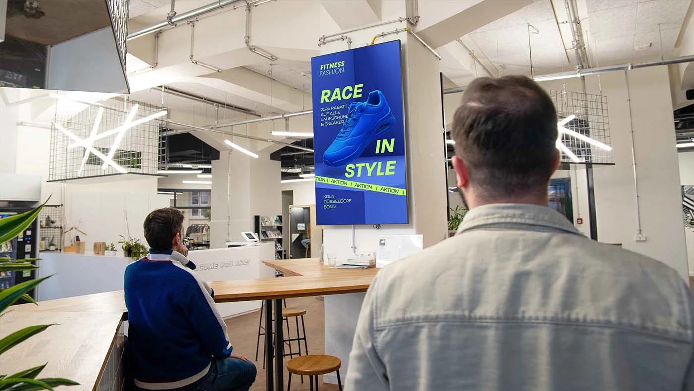 Digitaler Werbescreen in einem Caf&eacute;, G&auml;ste sitzen am Tresen