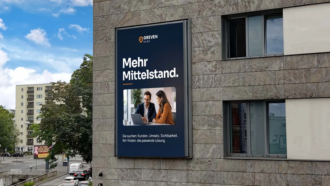 Digitale Greven-Medienwand an einer Hausfassade, darauf das Motiv &bdquo;Mehr Mittelstand&ldquo;