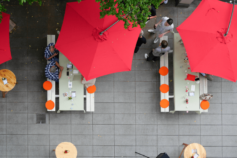 Dachterrasse mit roten Sonnenschirmen von oben