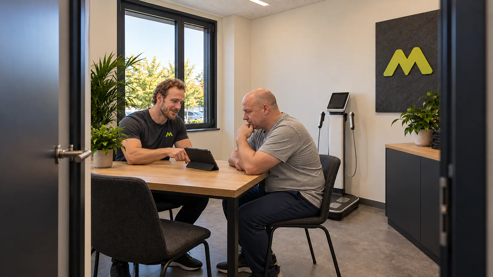 Leon bespricht einen Trainingsplan mit einem Mitglied.