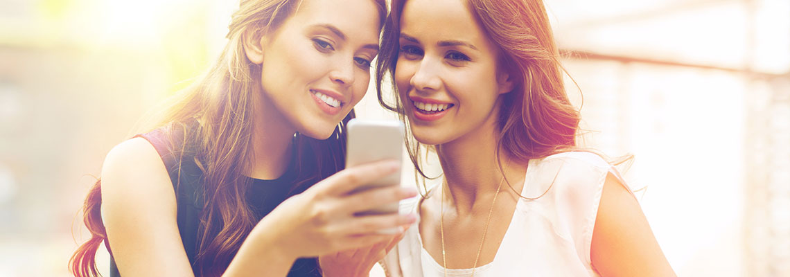 Zwei Frauen schauen auf einem Smartphone Facebook Ads